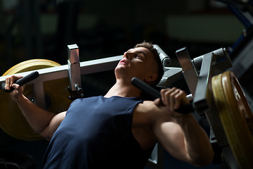 Image showing man doing chest press on exercise machine in gym