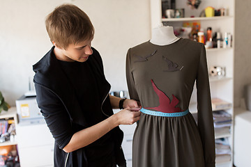 Image showing fashion designer with dummy making dress at studio