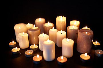 Image showing candles burning in darkness over black background