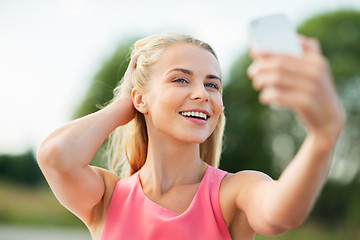 Image showing happy woman taking selfie with smartphone outdoors