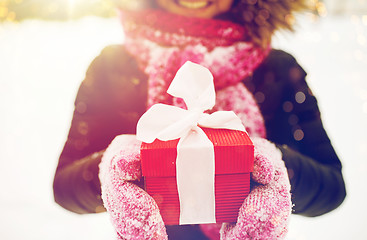 Image showing close up of woman with christmas gift outdoors