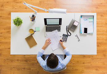 Image showing businesswoman with tax report at office