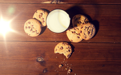 Image showing close up of oat cookies and milk on wooden table