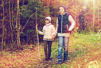 Image showing two happy kids walking along forest path