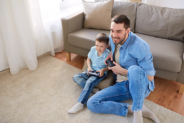 Image showing father and son playing video game at home