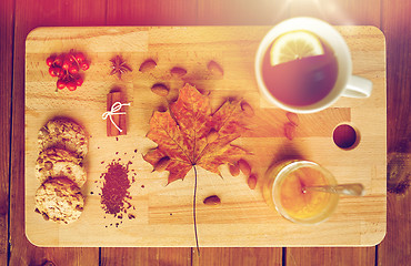 Image showing cup of tea with lemon, honey and cookies on board