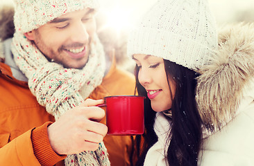 Image showing happy couple with tea cups over winter landscape