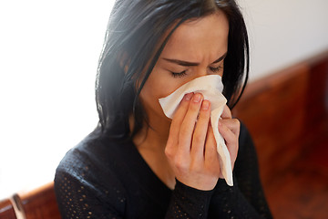 Image showing crying woman blowing nose with wipe at funeral day