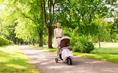 Image showing happy mother with child in stroller at summer park