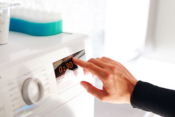 Image showing man choosing program for washing machine 