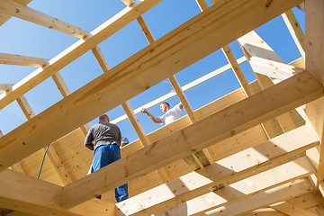 Image showing Builders at work with wooden roof construction.