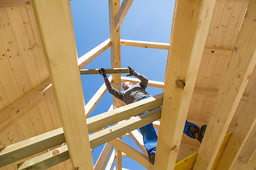 Image showing Builder at work with wooden roof construction.