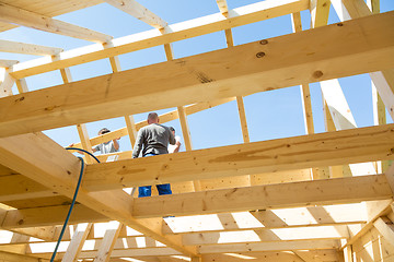 Image showing Builders at work with wooden roof construction.