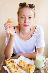 Image showing Woman eating traditional moroccan breakfast in coffee shop.