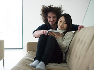 Image showing multiethnic couple at home using tablet computers