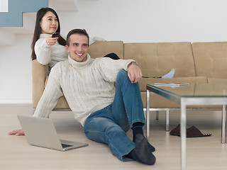 Image showing multiethnic couple on the sofa watching television