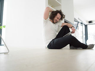 Image showing young man using a tablet at home