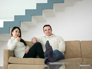 Image showing multiethnic couple on the sofa watching television