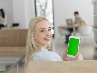 Image showing young woman using tablet computer in front of fireplace