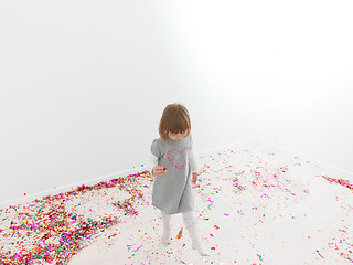 Image showing Little girl standing on confetti