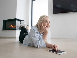 Image showing woman using tablet computer in front of fireplace