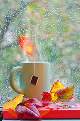 Image showing Autumn rainy window with hot tea