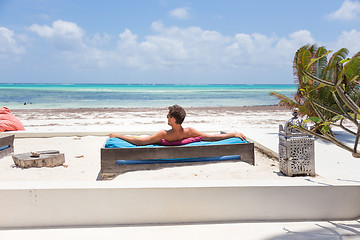 Image showing Relaxed man in luxury lounger enjoying summer vacations on beautiful beach.