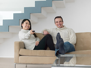 Image showing multiethnic couple on the sofa watching television