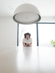 Image showing young man using a tablet at home