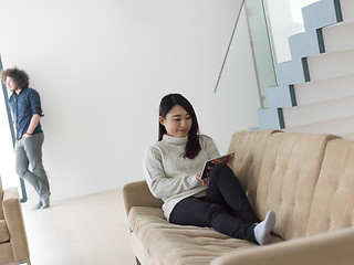 Image showing multiethnic couple at home using tablet computers