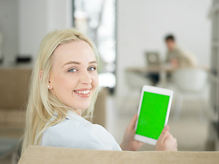 Image showing young woman using tablet computer in front of fireplace