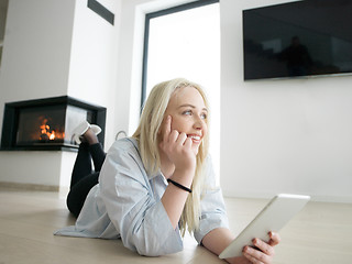 Image showing woman using tablet computer in front of fireplace