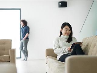 Image showing multiethnic couple at home using tablet computers