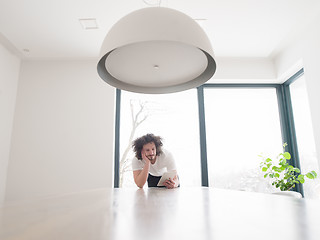 Image showing young man using a tablet at home