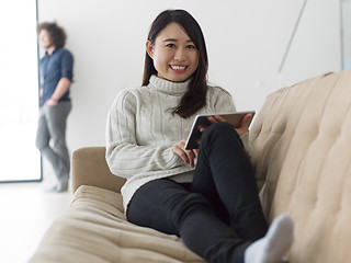 Image showing multiethnic couple at home using tablet computers