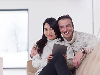 Image showing multiethnic couple at home using tablet computers