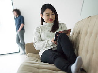 Image showing multiethnic couple at home using tablet computers