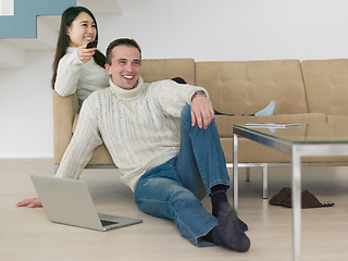 Image showing multiethnic couple on the sofa watching television