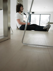 Image showing young man using a tablet at home