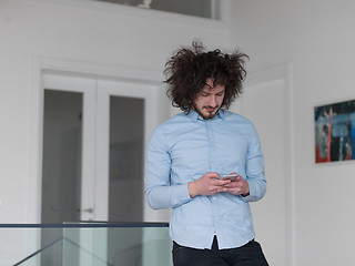 Image showing man using a mobile phone  at home