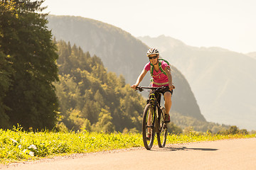 Image showing Active sporty woman riding mountain bike in nature.