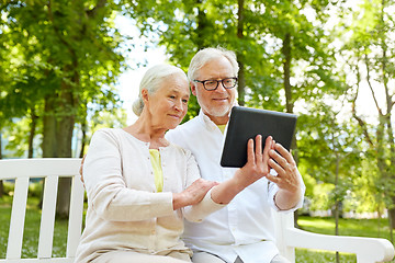 Image showing happy senior couple with tablet pc in city park