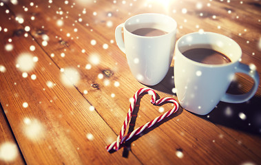 Image showing christmas candy canes and cups on wooden table