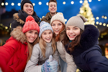 Image showing happy friends taking selfie outdoors at christmas