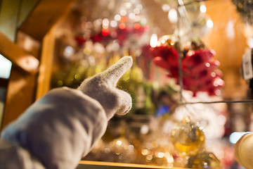 Image showing hand pointing at christmas toys behind shop window