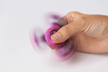 Image showing close up of hand playing with fidget spinner