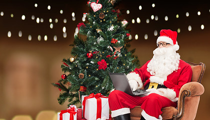 Image showing man in costume of santa claus with laptop