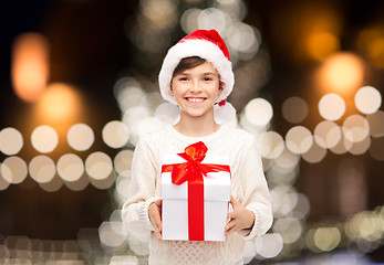 Image showing smiling happy boy in santa hat with christmas gift