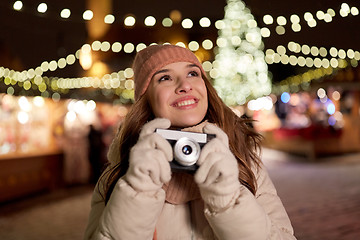 Image showing happy young woman with camera at christmas market