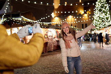 Image showing happy woman posing for smartphone at christmas